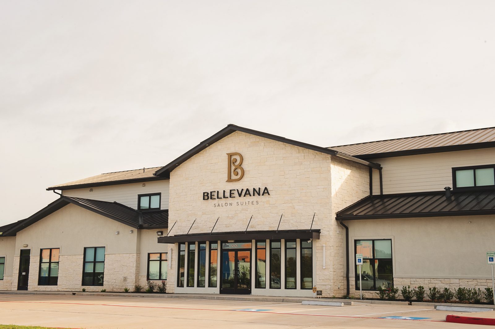 Close angled view of the Bellevana Salon Suites entrance with gold logo signage