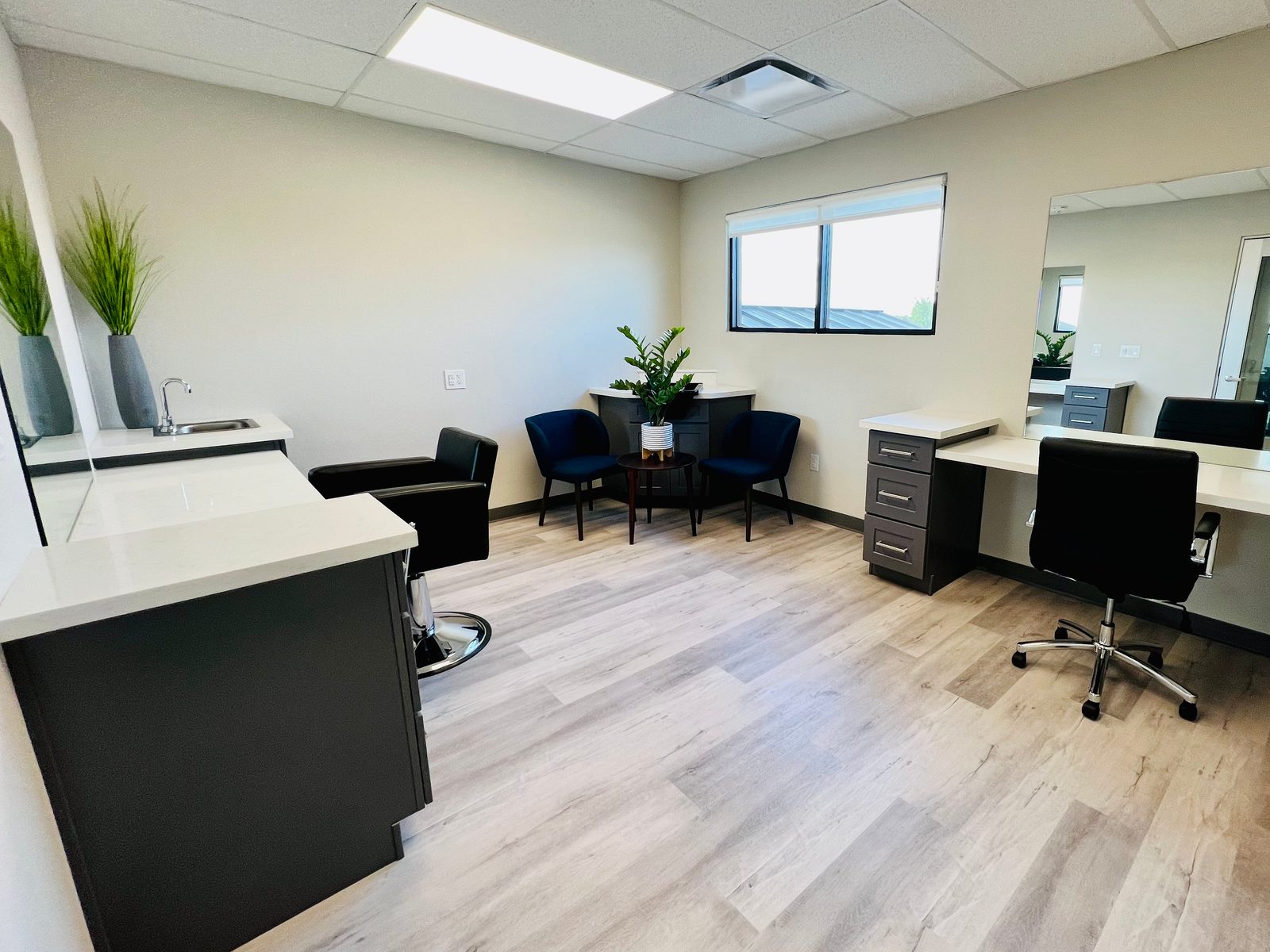 Private Bellevana salon suite with shampoo sink, styling chair, seating nook, mirror station, and window